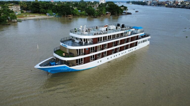 Luxurious cruise ship on calm river waters.